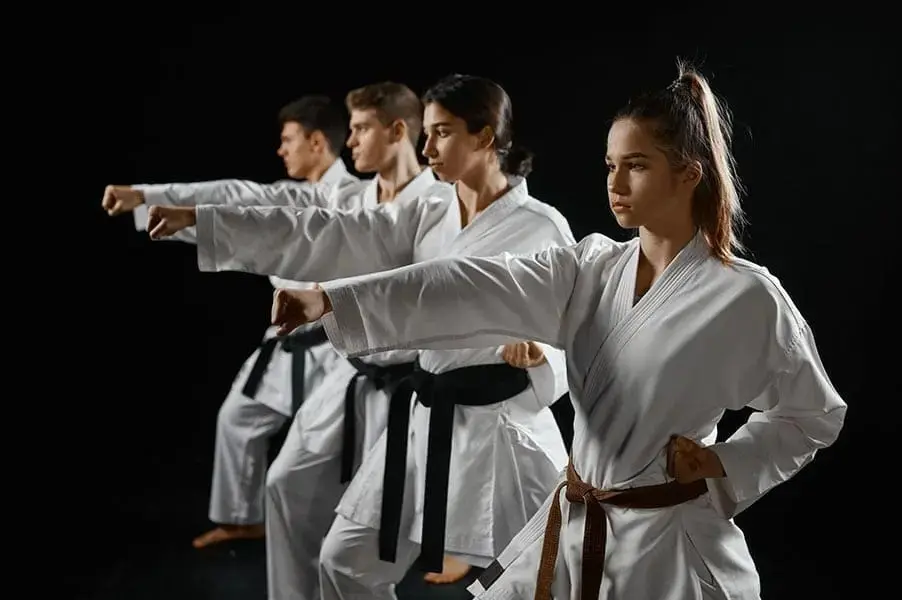 Martial arts students practicing synchronized punches during a structured class session.