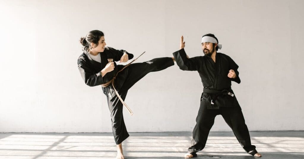 male instructor with a beard and a patterned headband demonstrates a defensive blocking technique during a session of martial arts for beginners.