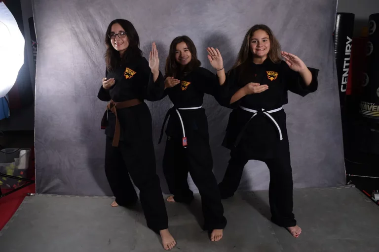 Teen martial arts students posing confidently in uniform after class