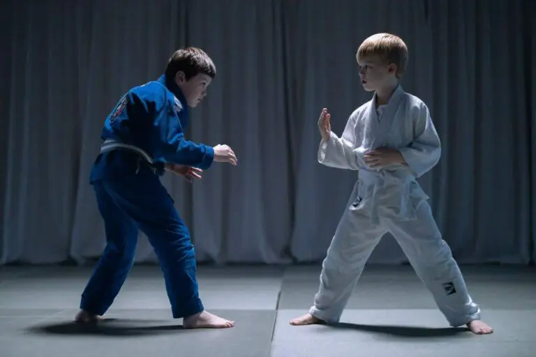 Two children practicing a ready stance and personal space awareness during martial arts training for kids self defense boundary skills